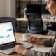 Marketing specialist reviewing PPC campaign metrics on a laptop in an office