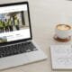 Laptop showing a contractor landing page with a notepad and coffee on a desk